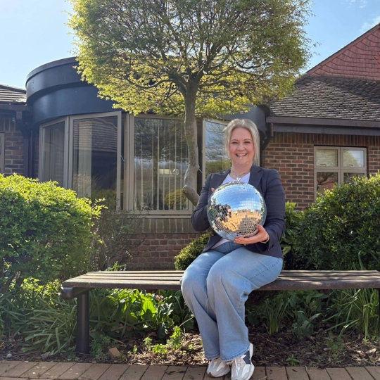 A photo of Beverly holding the Strictly St. Rocco's Glitter ball