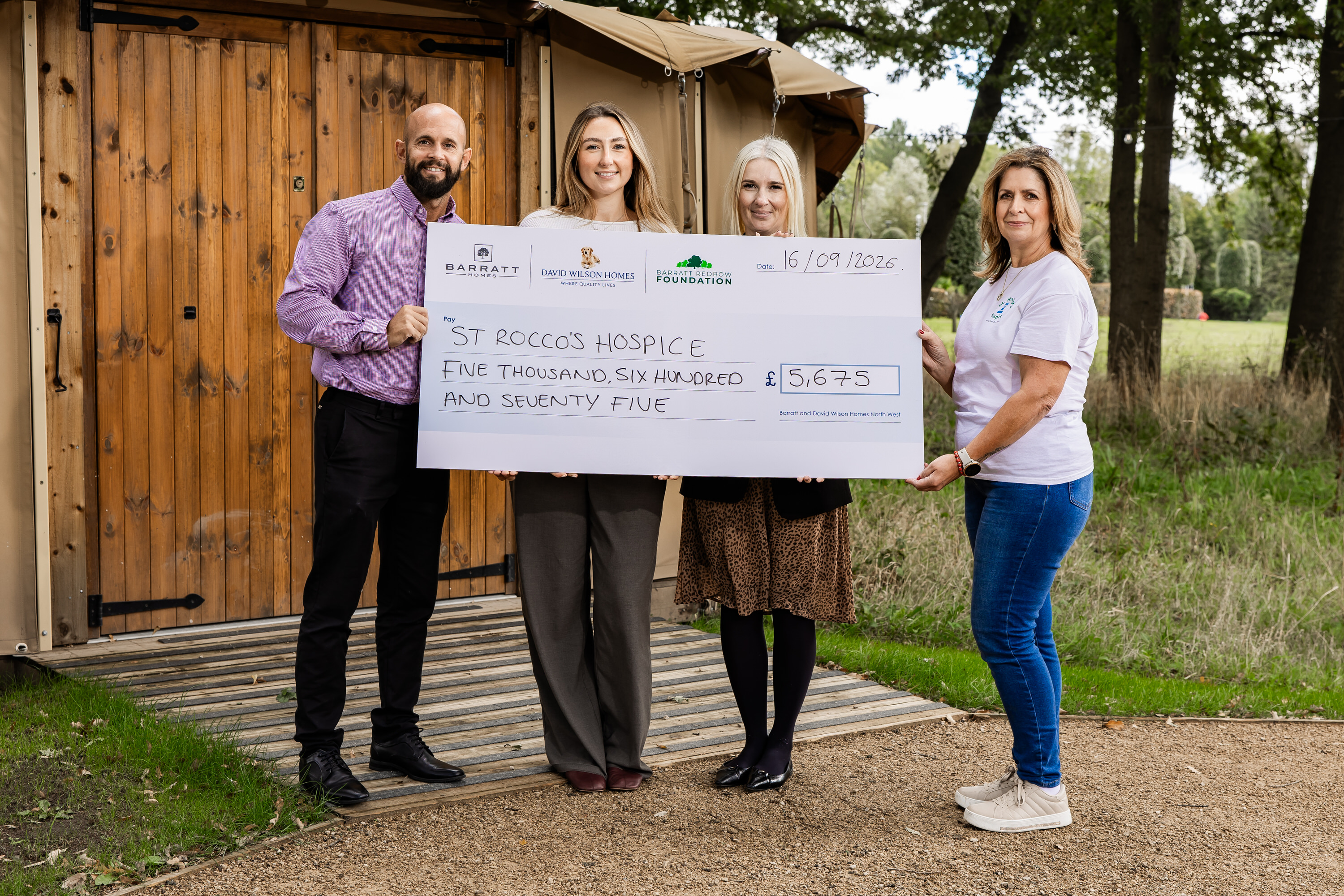 A photo of the Village Hotel staff and St. Rocco's staff holding a cheque