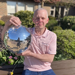 A photo of Craig holding the Strictly St. Rocco's Glitter ball