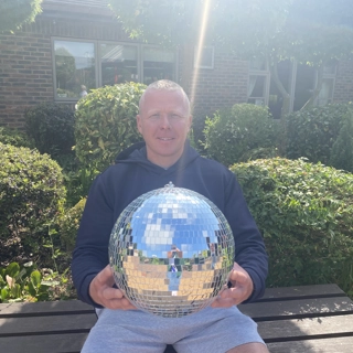A photo of John holding the Strictly St. Rocco's Glitter ball