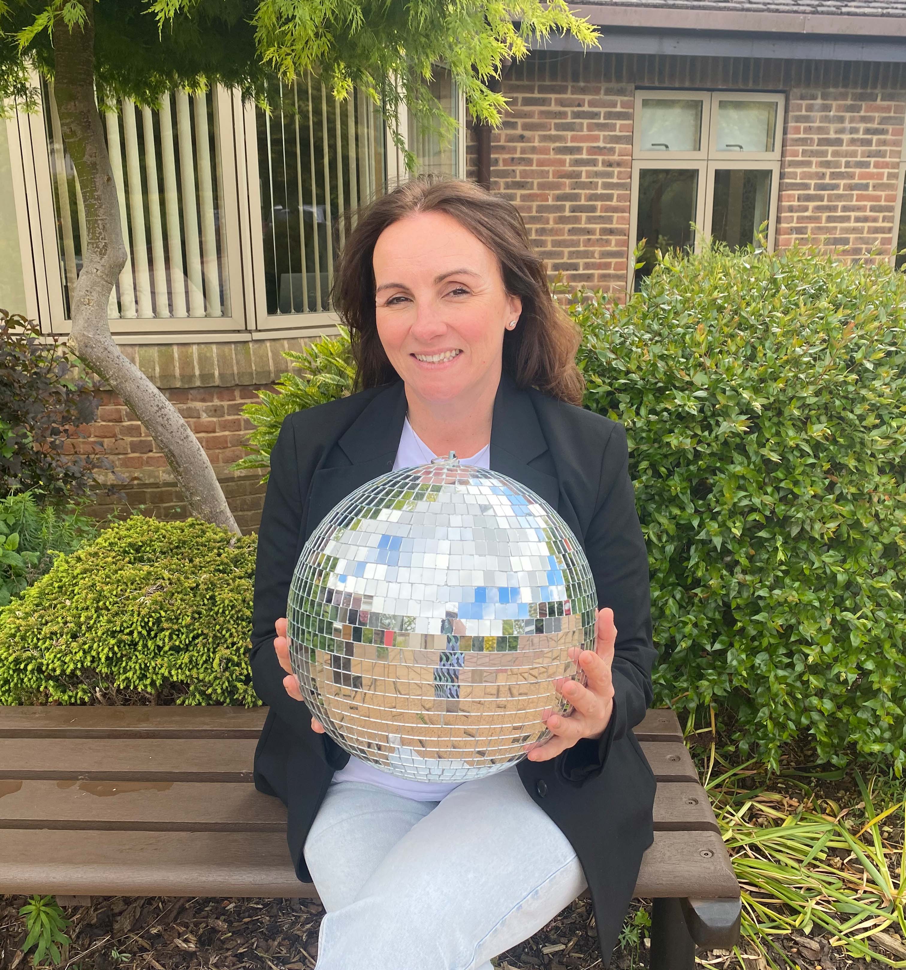A photo of Steph holding the Strictly St. Rocco's Glitter ball