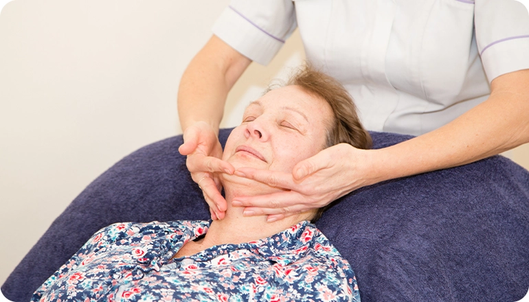 A nurse massaging a patients neck