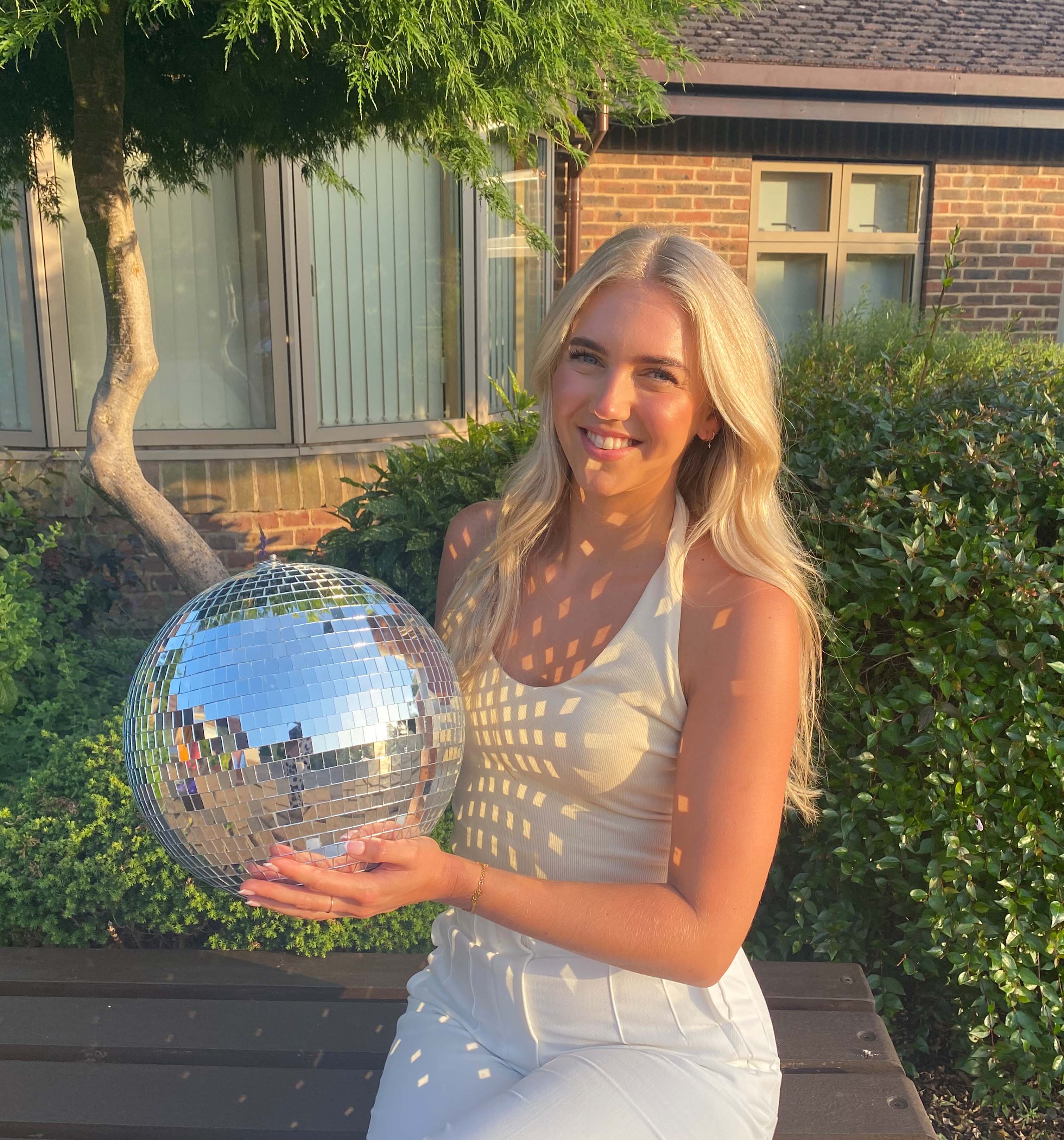 A photo of Louise holding the Strictly St. Rocco's Glitter ball