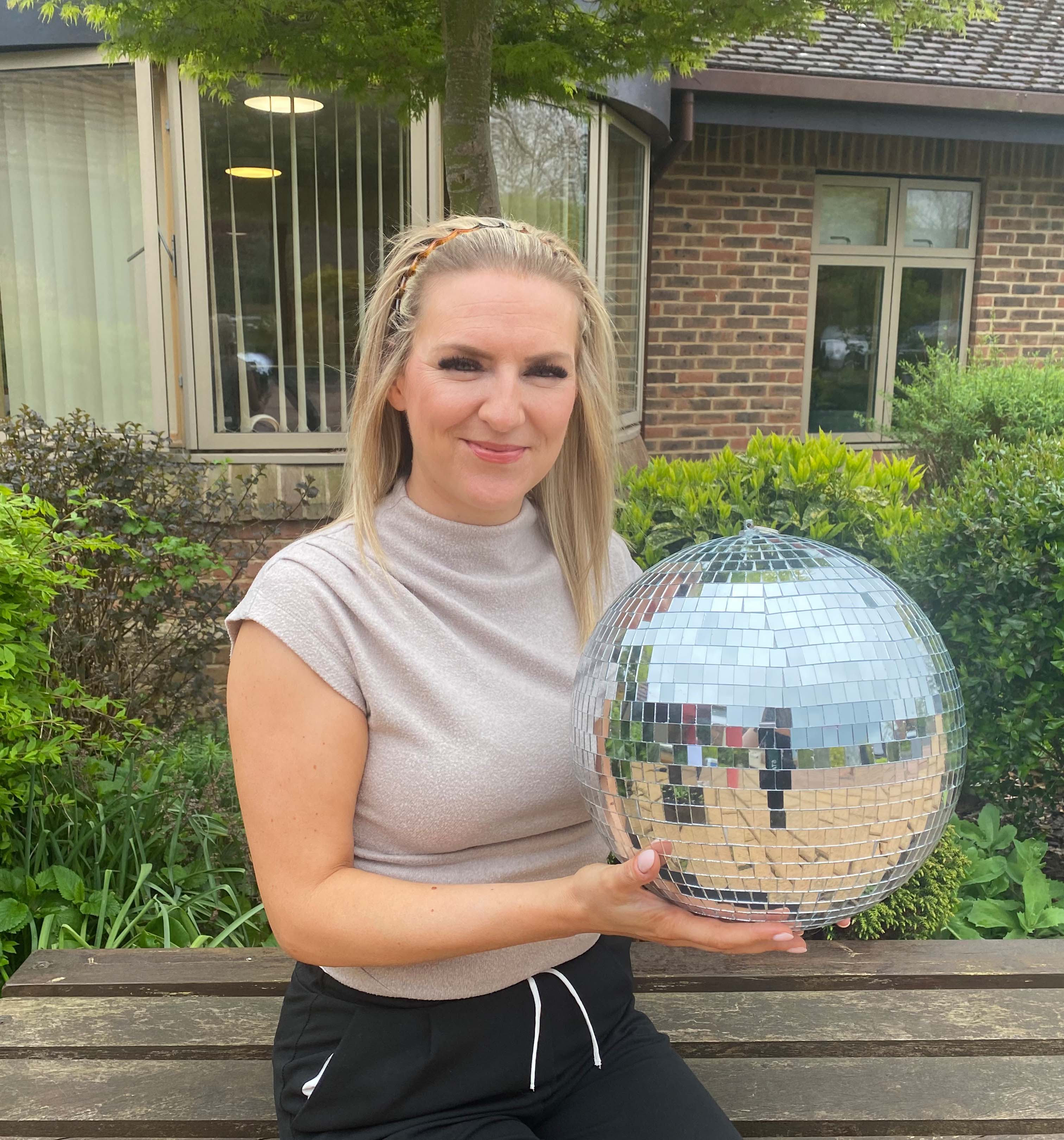 A photo of Danielle holding the Strictly St. Rocco's Glitter ball