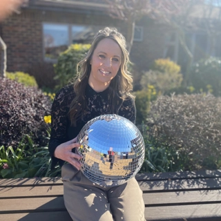 A photo of Louise holding the Strictly St. Rocco's Glitter ball