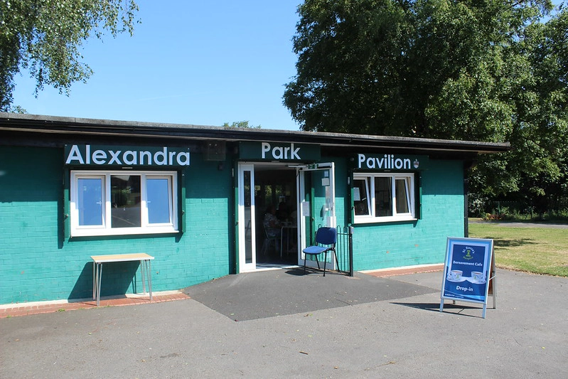 A photo of the Green Alexadra Park Pavilion, with a St. Rocco's Bereavement Cafe Sign outside