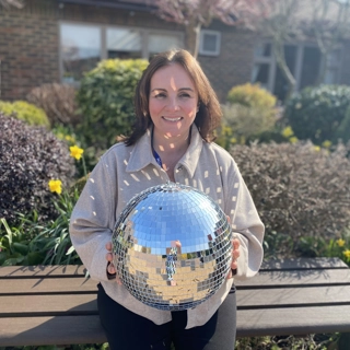 A photo of Steph holding the Strictly St. Rocco's Glitter ball