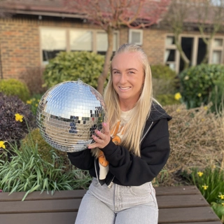 A photo of Micah holding the Strictly St. Rocco's Glitter ball