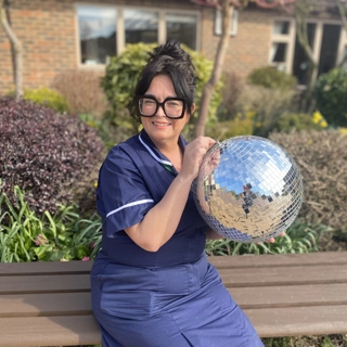 A photo of Claire holding the Strictly St. Rocco's Glitter ball