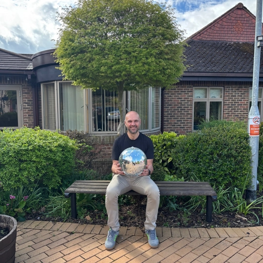 A photo of Chris holding the Strictly St. Rocco's Glitter ball