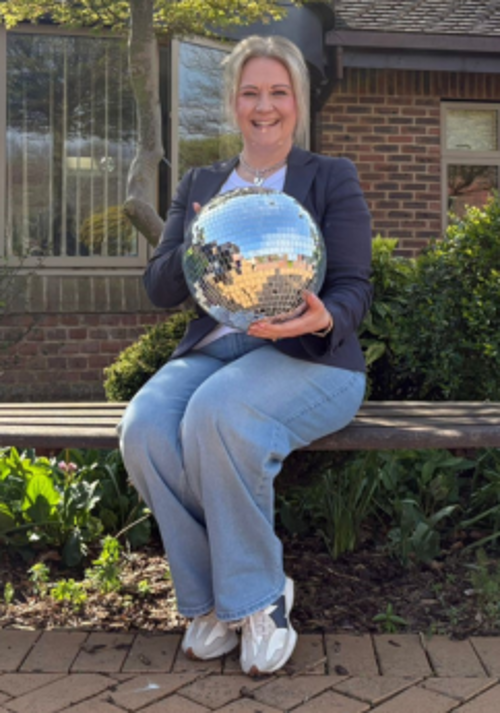 A photo of Beverly holding the Strictly St. Rocco's Glitter ball